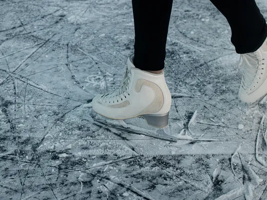 White ice skates on a scratched ice surface
