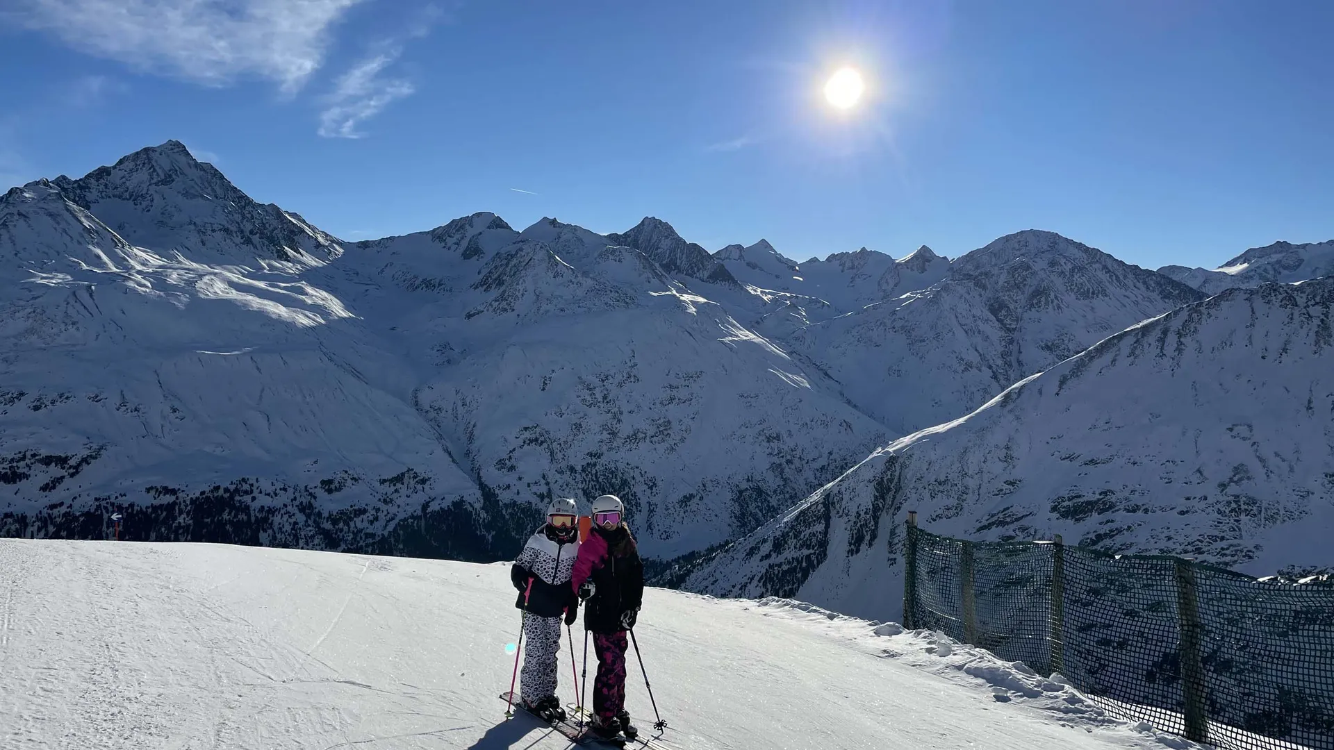 Gasthof Weisskugel: Bilder, die Sehnsucht wecken Zwei Skifahrerinnen auf einer sonnigen Piste vor einer verschneiten Berglandschaft