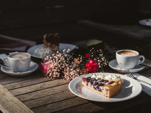 Gasthof Weisskugel: your authentic restaurant in Vent Coffee, berry cake and flowers on a wooden table