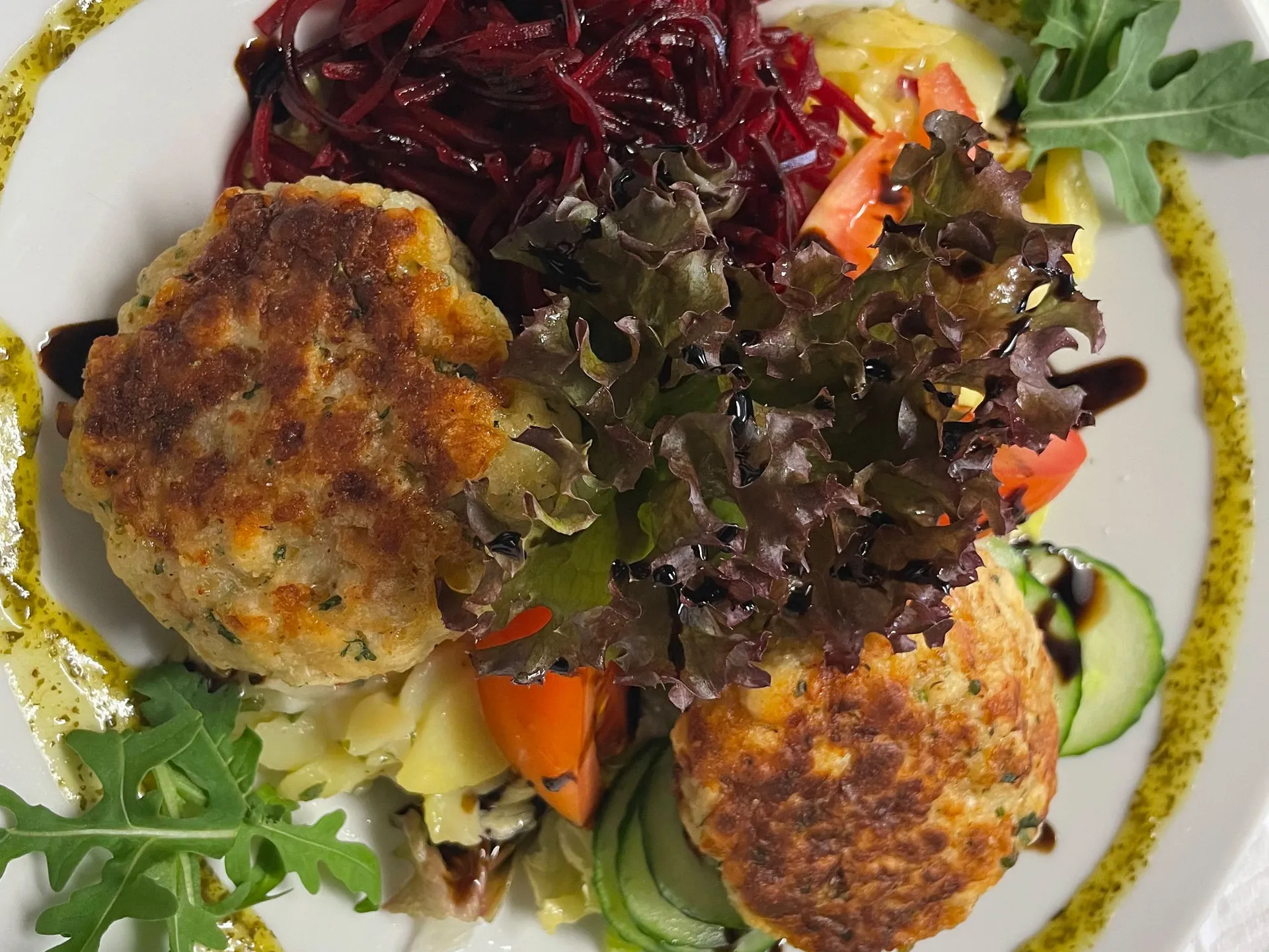 Gasthof Weisskugel: dein originales Restaurant in Vent Teller mit zwei gebratenen Bratlingen, Rote-Bete-Salat, Blattsalat und Gemüse