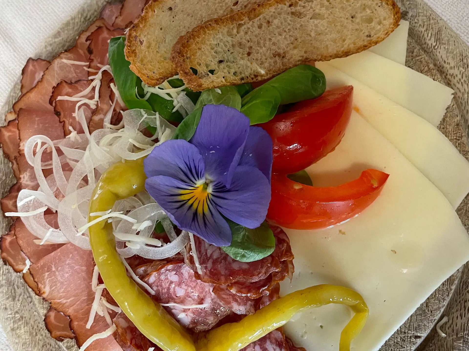 Gasthof Weisskugel: dein originales Restaurant in Vent Wurst- und Käsescheiben mit Brot, Paprika, Tomaten und essbarer Blüte