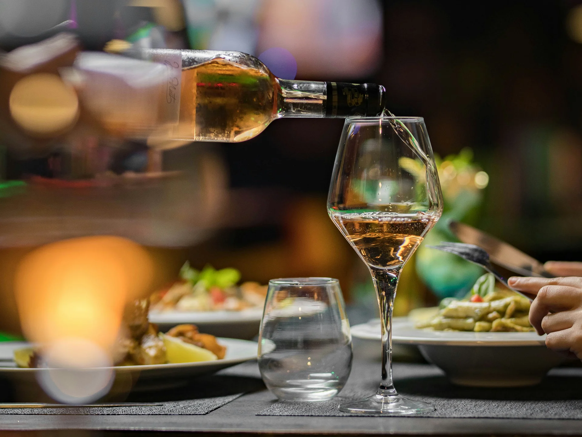 Gasthof Weisskugel: dein originales Restaurant in Vent Wein wird in ein Glas am gedeckten Restauranttisch eingeschenkt