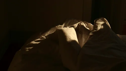 Gasthof Weisskugel: imprint Unordentliches Bett mit zerknitterter Bettwäsche im schwachen Licht