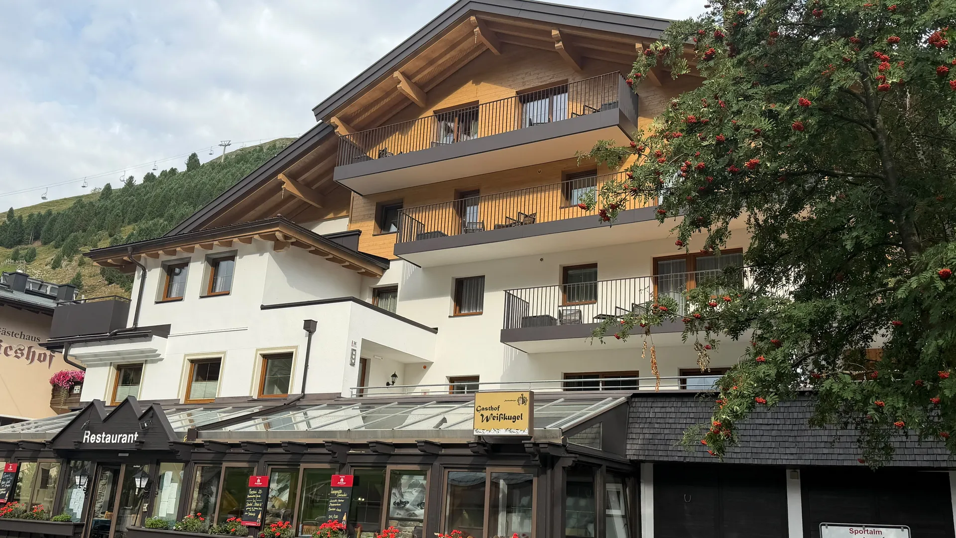 Gasthof Weisskugel: Bilder, die Sehnsucht wecken Alpengasthof mit Balkonen, Restaurant und blühendem Vogelbeerbaum