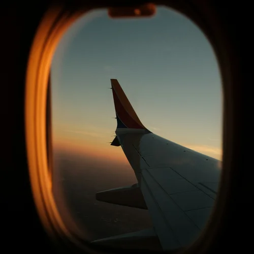 Your cosy retreats: rooms and suites at the Weisskugel Airplane wing at sunset seen through the window