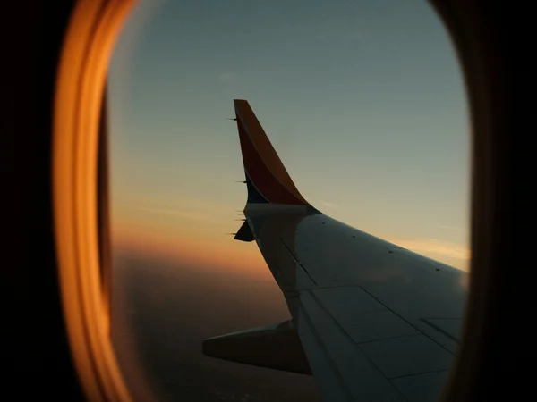 Your cosy retreats: rooms and suites at the Weisskugel Airplane wing at sunset seen through the window
