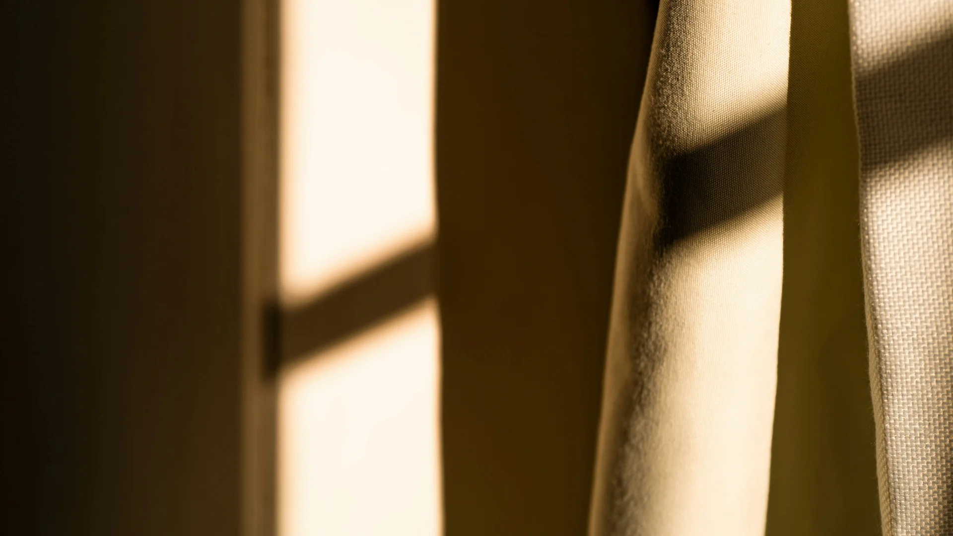 Weisskugel: your accommodation in Tyrol Sonnenlicht wirft Schatten auf einen cremefarbenen Vorhang