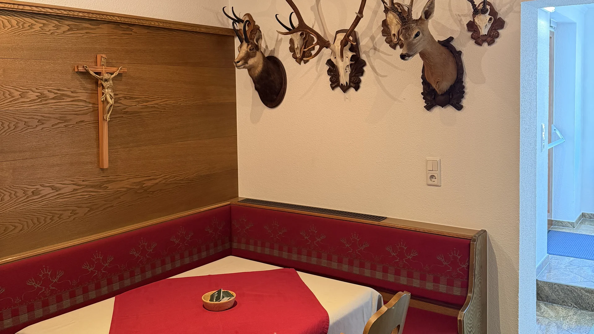 Rustikale Sitzecke mit gedecktem Tisch, Holzdecke und Trophäen an der Wand