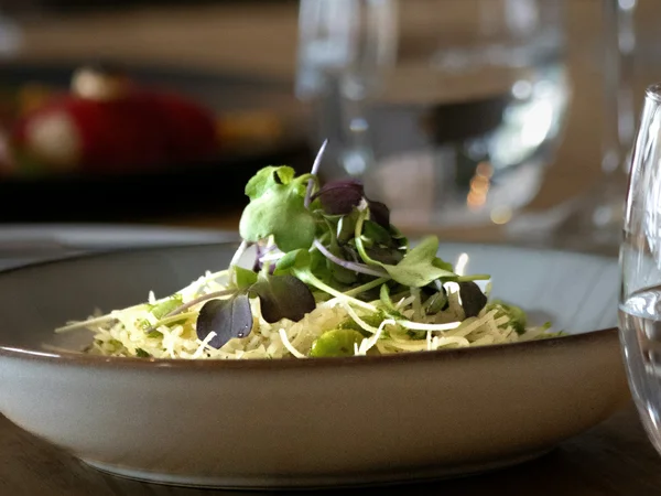 Gasthof Weisskugel in Vent: family-run since the beginning Plate of salad with sprouts and green leaves on a set dining table