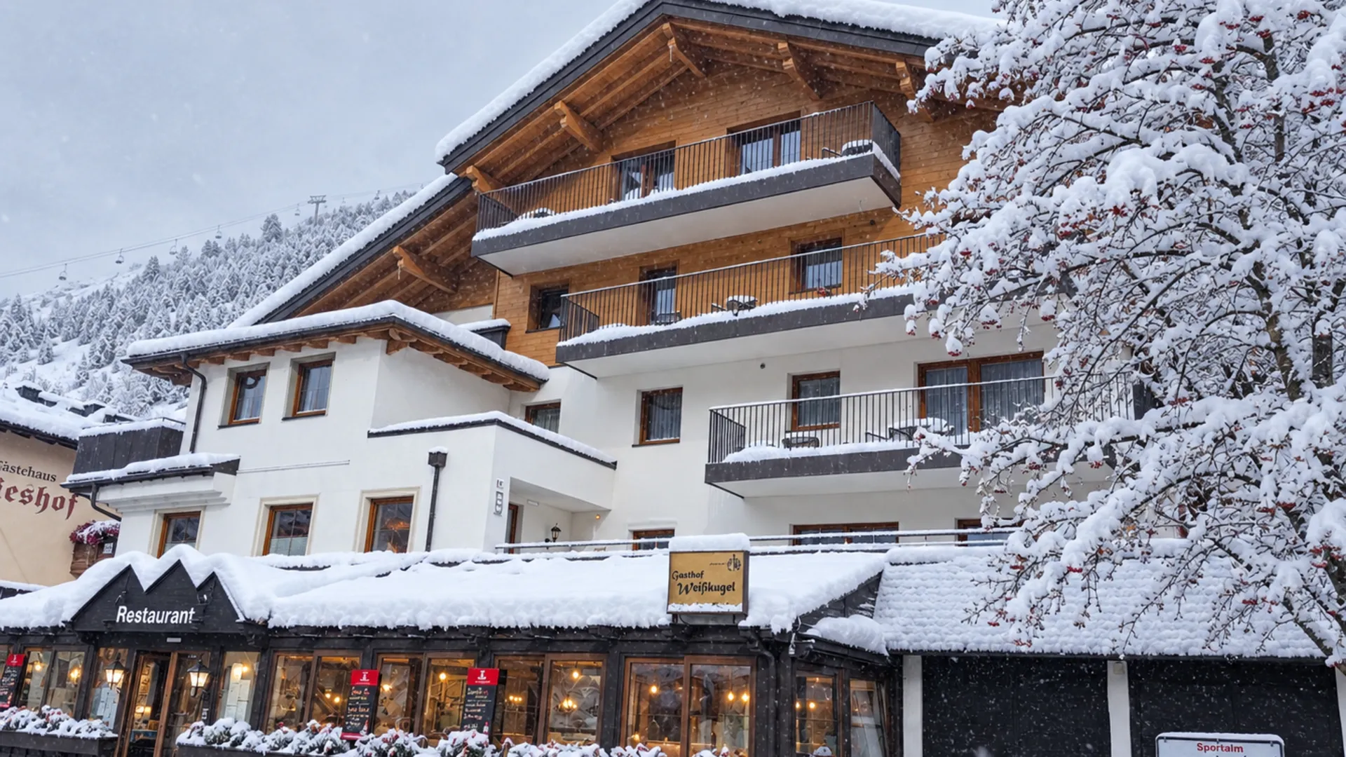 Gasthof Weisskugel: Bilder, die Sehnsucht wecken Verschneiter Gasthof mit Restaurant und Holzbalkonen in einem alpinen Ort