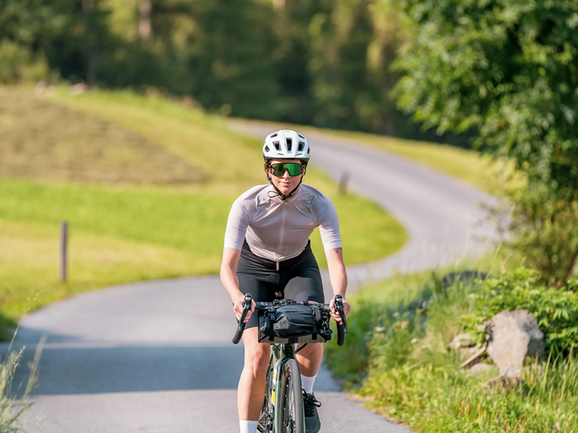 Weisskugel: your accommodation in Tyrol Frau fährt Fahrrad auf kurviger Landstraße umgeben von grüner Natur