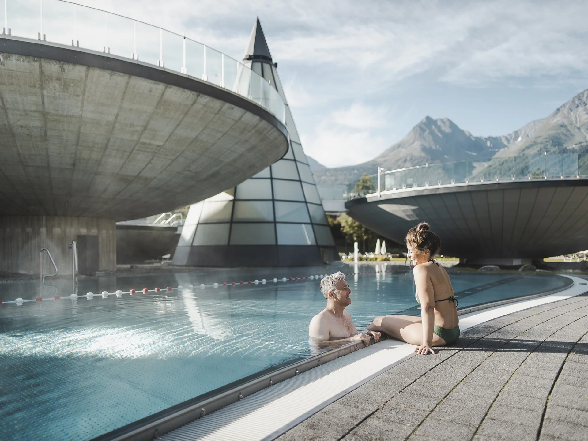 Weisskugel: your accommodation in Tyrol Älteres Paar entspannt am Außenpool mit moderner Architektur und Bergen im Hintergrund