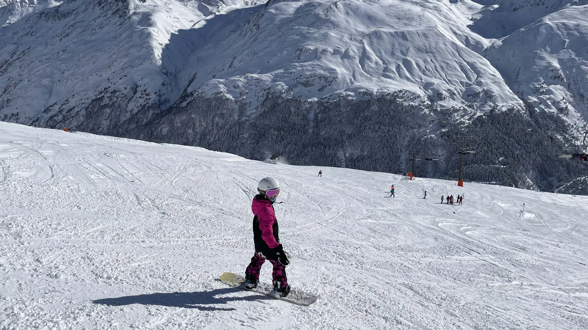 Gasthof Weisskugel: Bilder, die Sehnsucht wecken Snowboarder in pinker Jacke auf einer Piste vor schneebedeckten Bergen