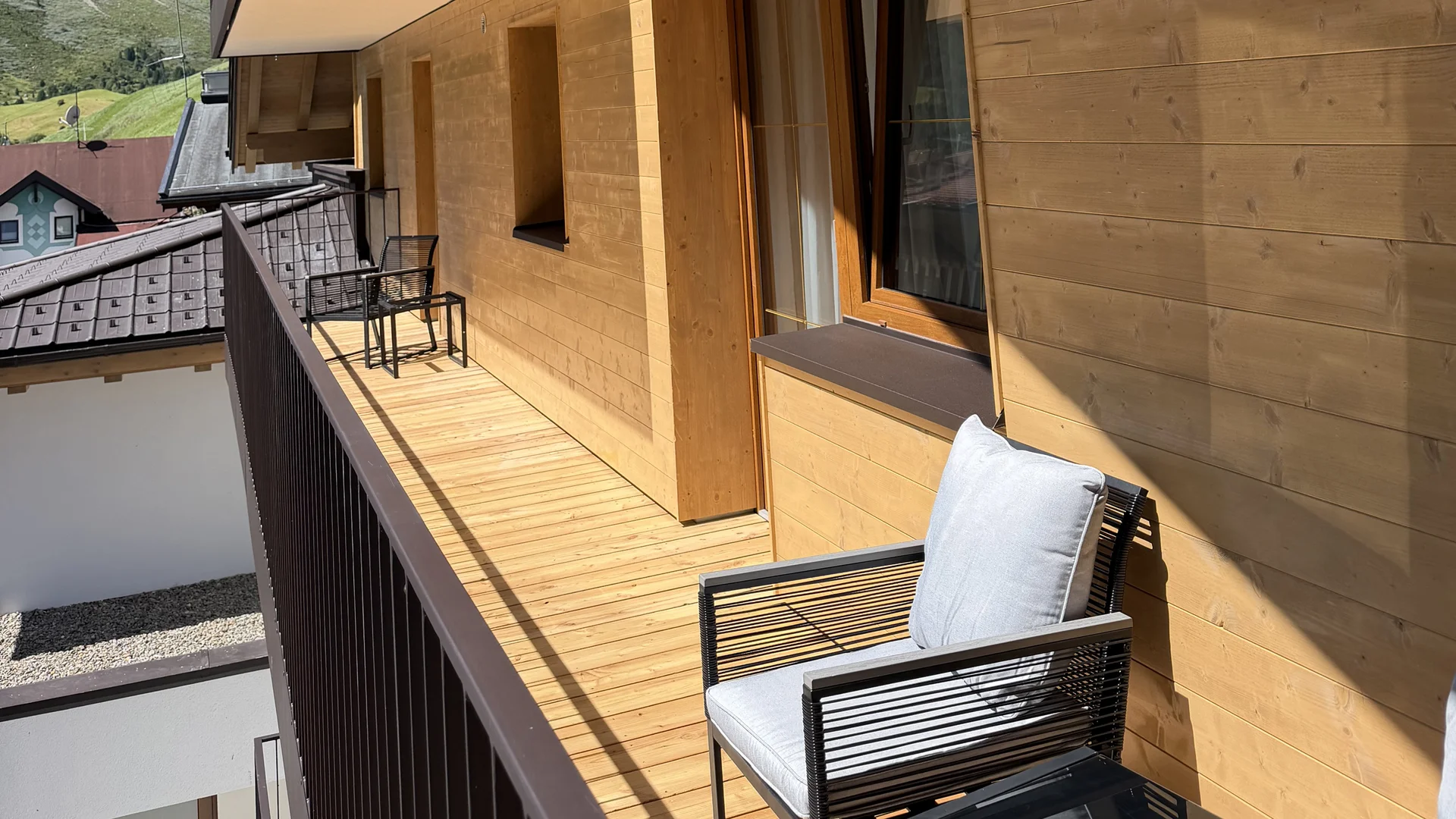 Wooden balcony with outdoor seating and views of the surrounding mountains