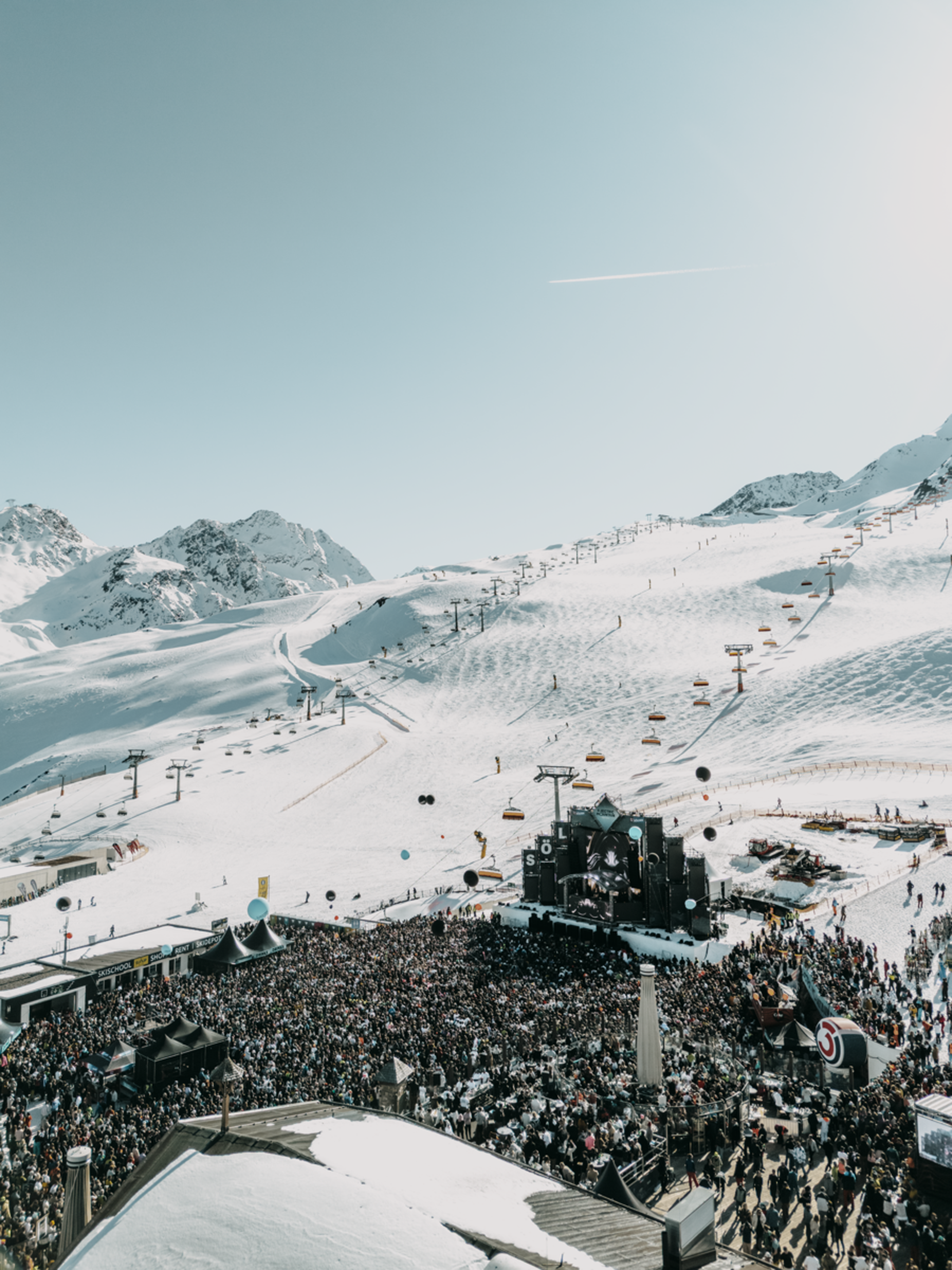 Großes Publikum bei Konzert im verschneiten Skigebiet mit Bergen im Hintergrund