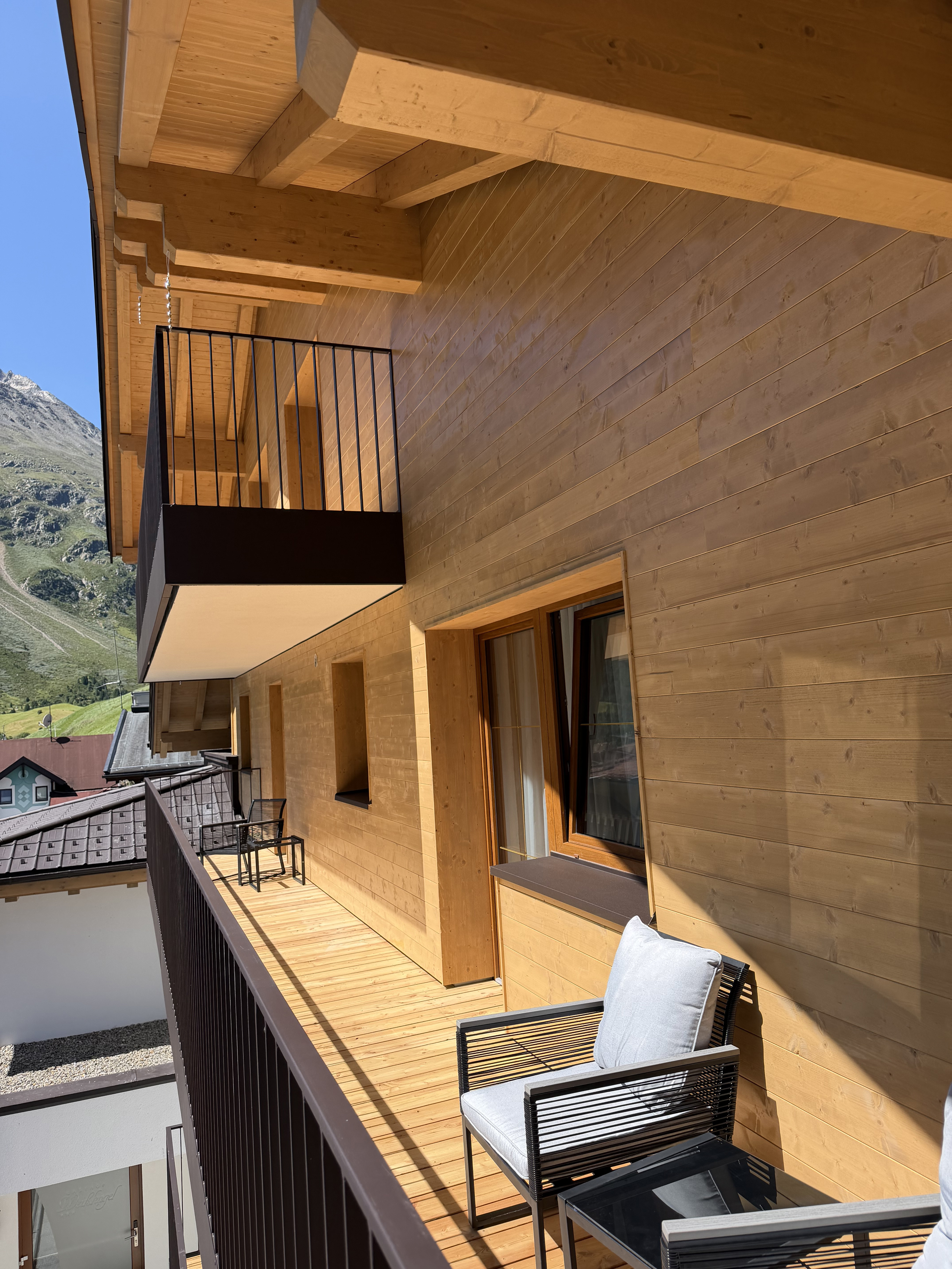 Wooden balcony with outdoor seating and views of the surrounding mountains