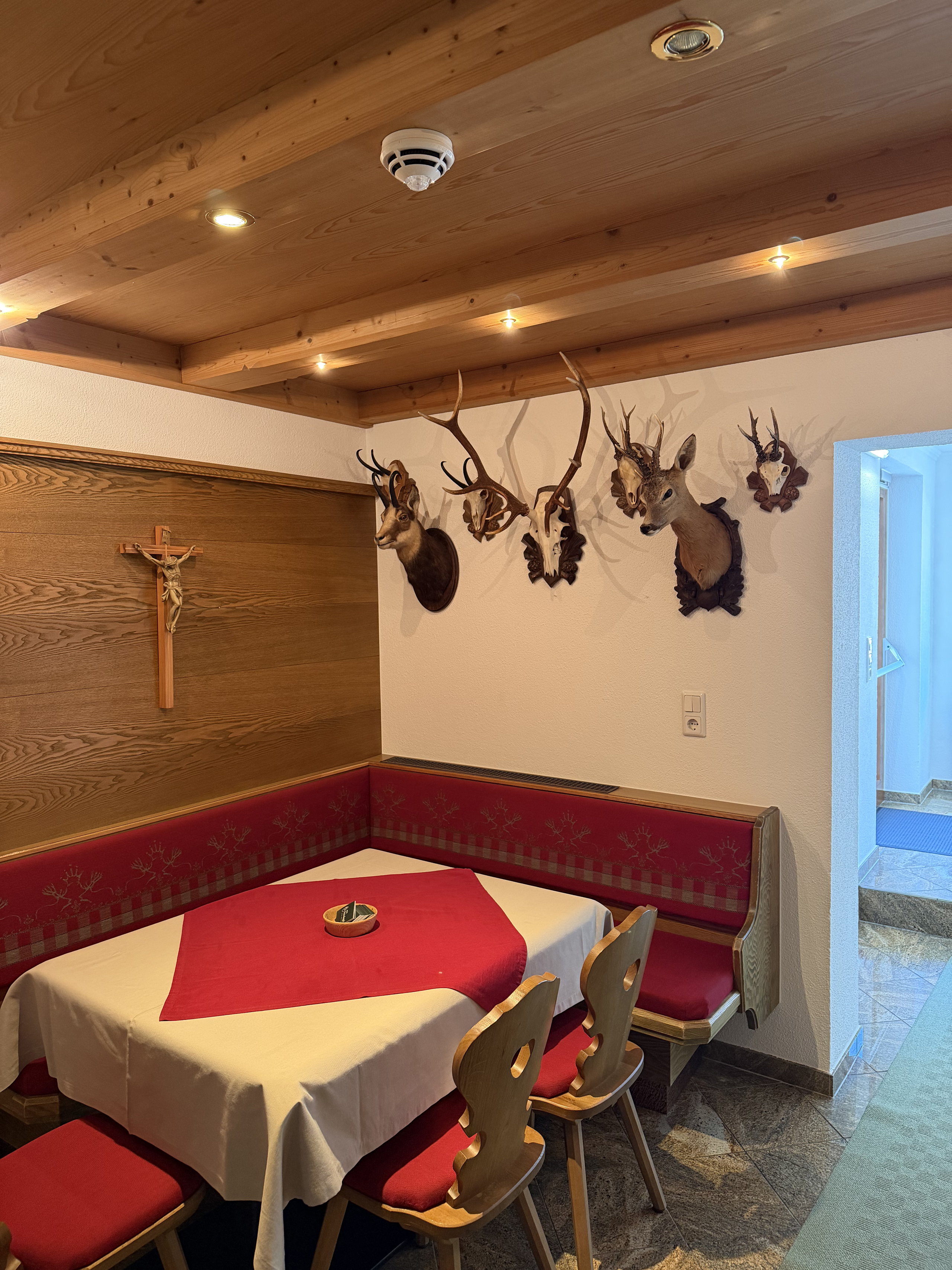 Rustic dining nook with set table, wood ceiling and trophies on the wall